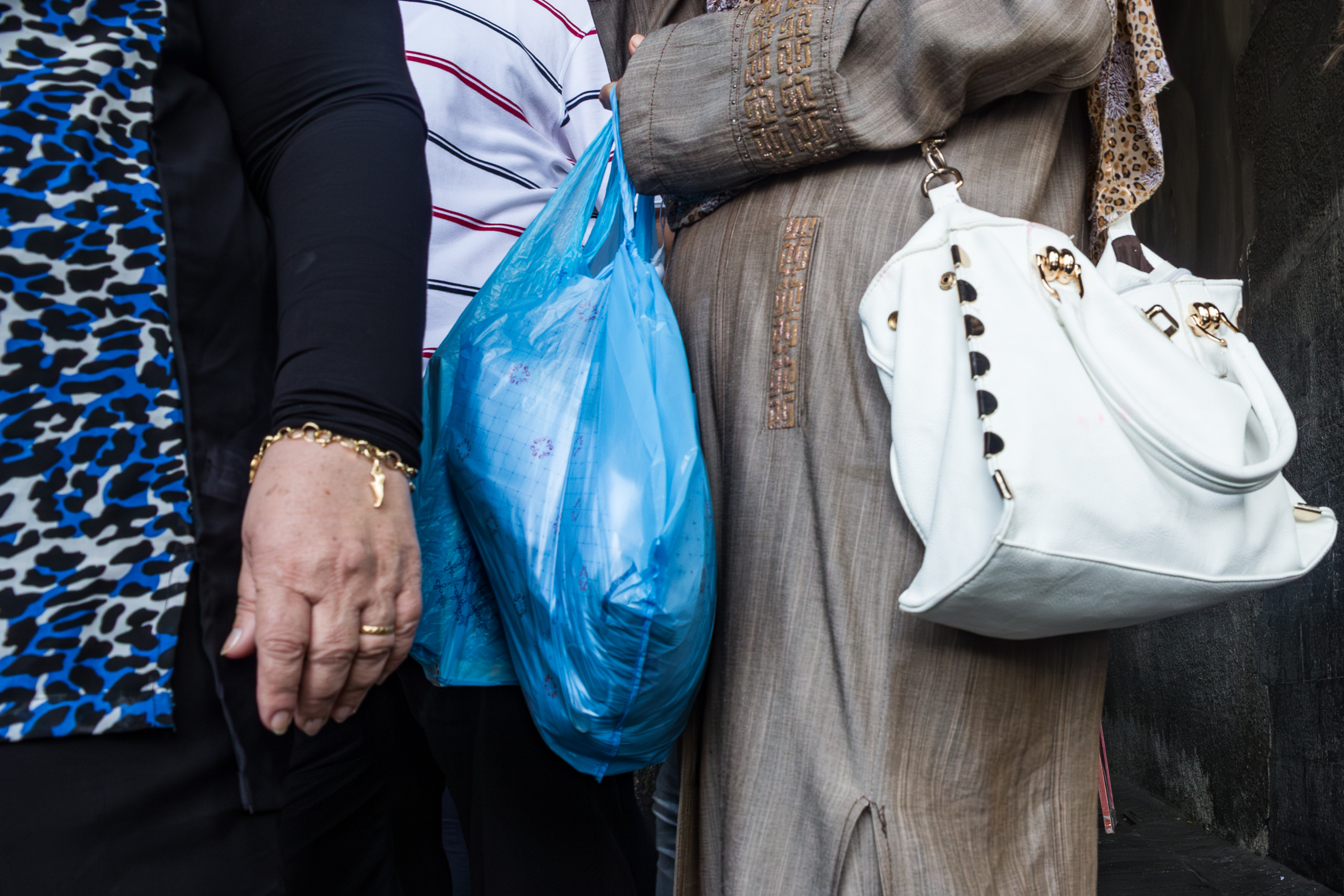 Detail am Straßenrand – Taschen und Hände im Gedränge
