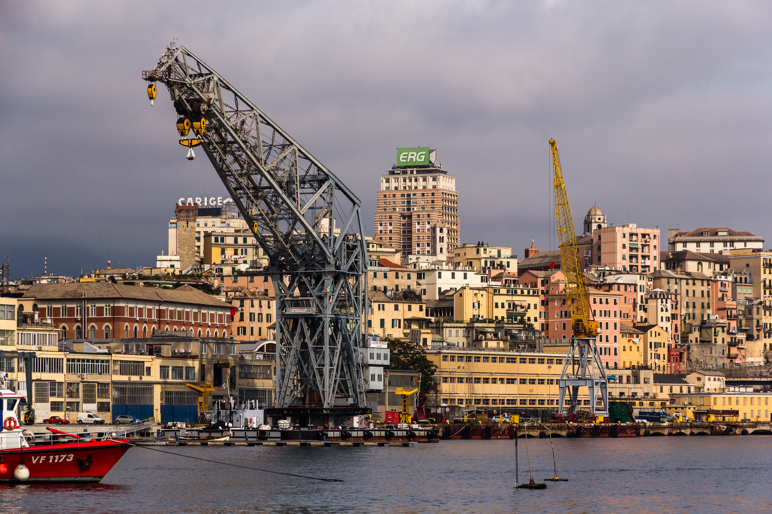 Genuas Hafen mit historischem Riesenkran und der Stadt am Hang