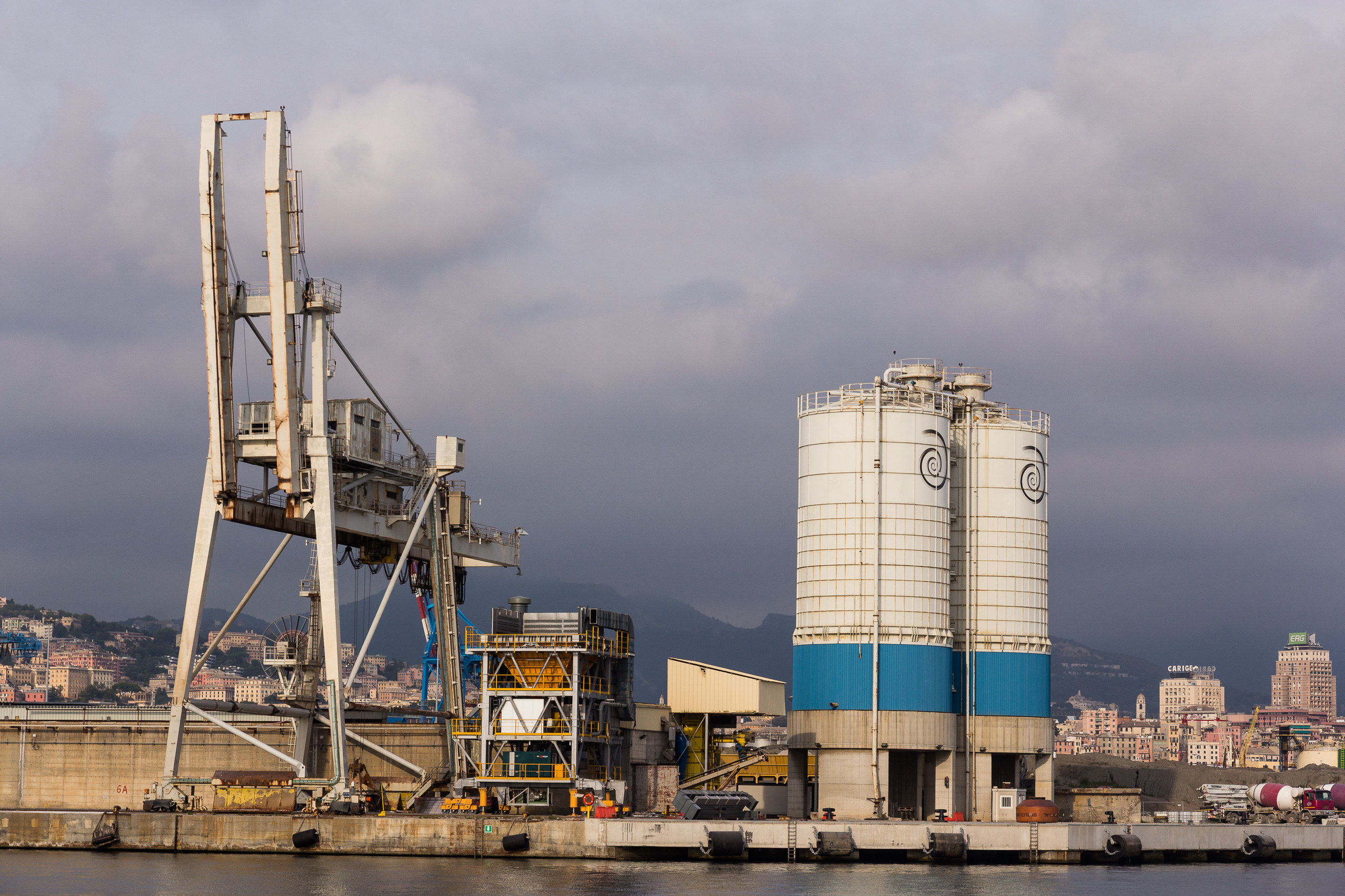 Silos und Kran im Hafen, dahinter die Stadt am Hang